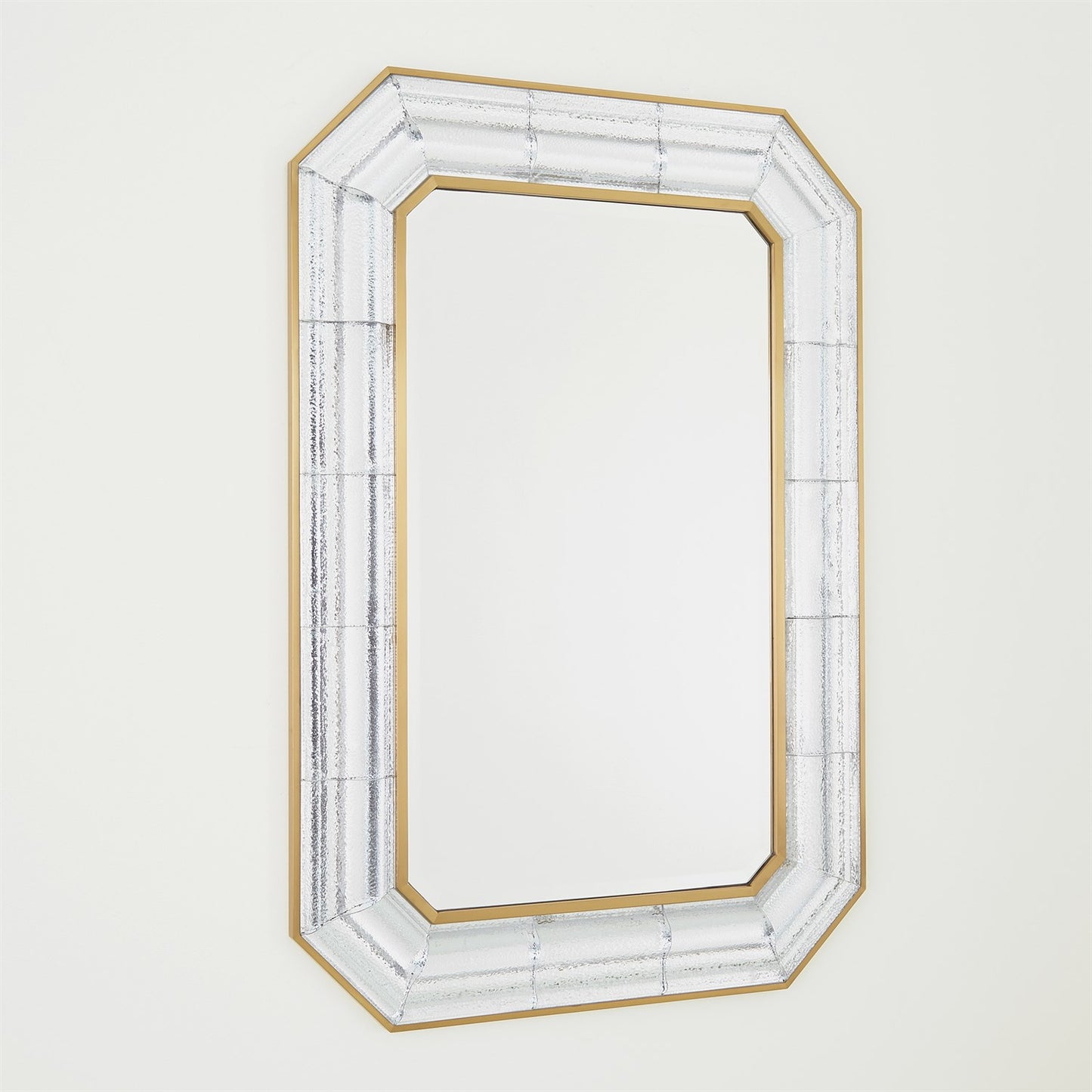 Decorative mirror with a gold and white frame on a light gray background