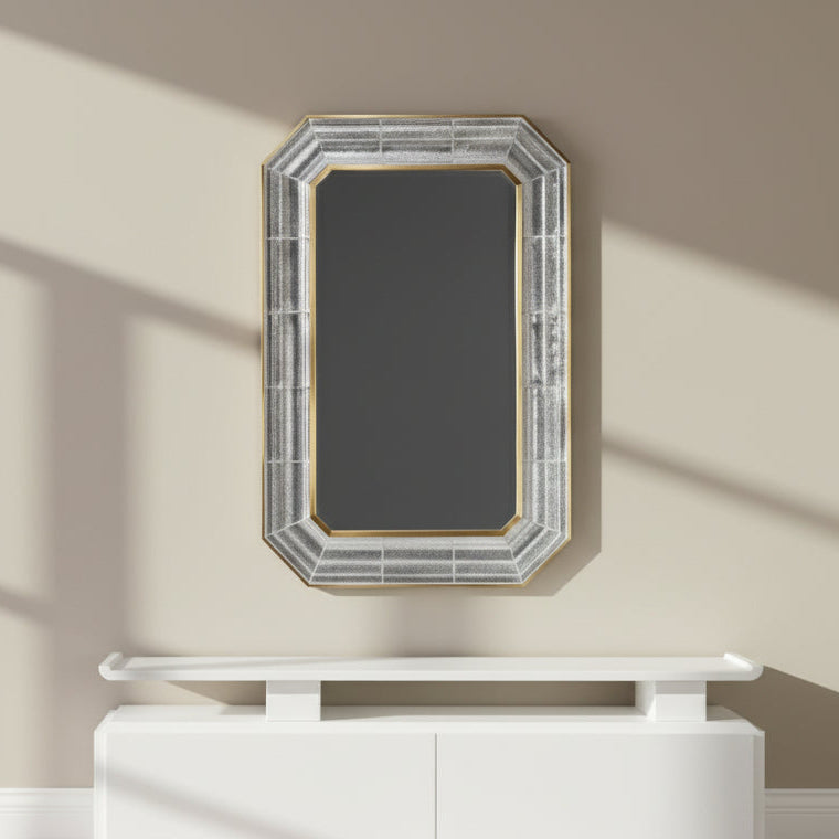 Decorative setup with a red console table, vase of red flowers, and mirror on a dark wall.