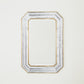Decorative mirror with a gold and silver frame on a white background