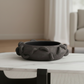 Decorative black bowl with textured rim on a marble surface