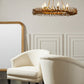 Patterned armchair with ottoman under a gold chandelier in a room with panelled walls.