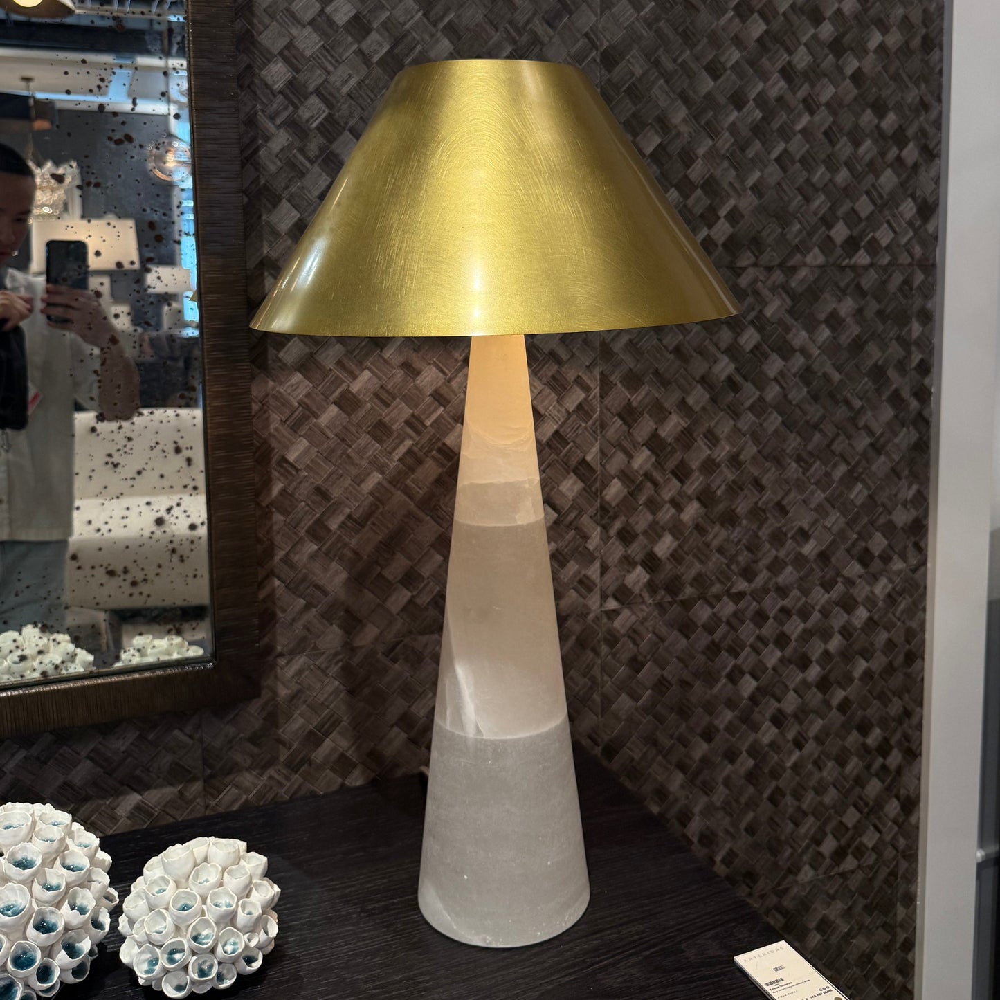 Decorative lamp with gold shade and marble base on a patterned surface