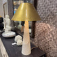 Decorative lampshades on a table with a patterned wall in the background