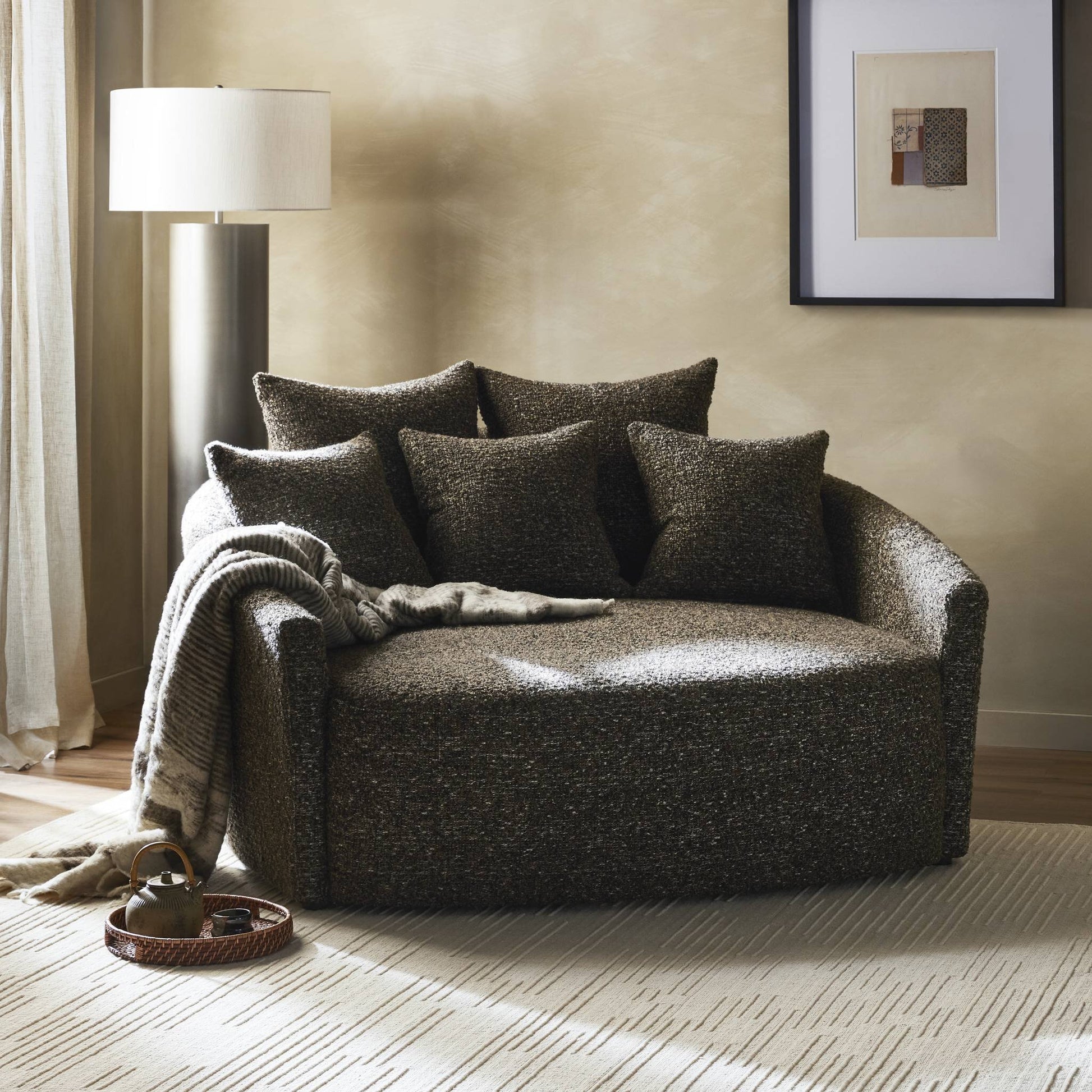 gray textured sofa with decorative pillows in a living room setting.