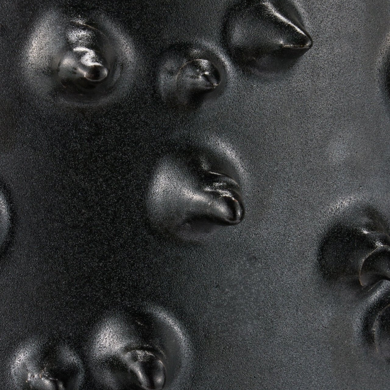 Close-up of a textured black surface with raised circular patterns