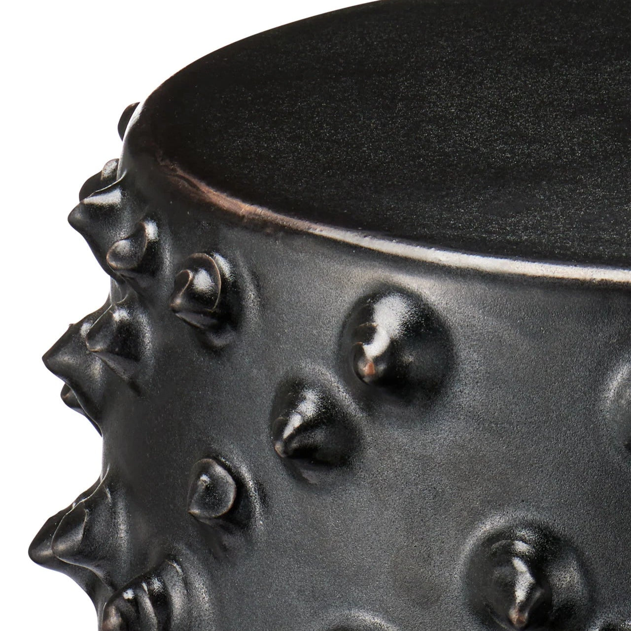 Black textured container with spiky design on a white background