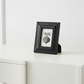Black photo frame with a small print on a white surface