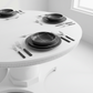 Round white table with black dinnerware set in a minimalistic room.
