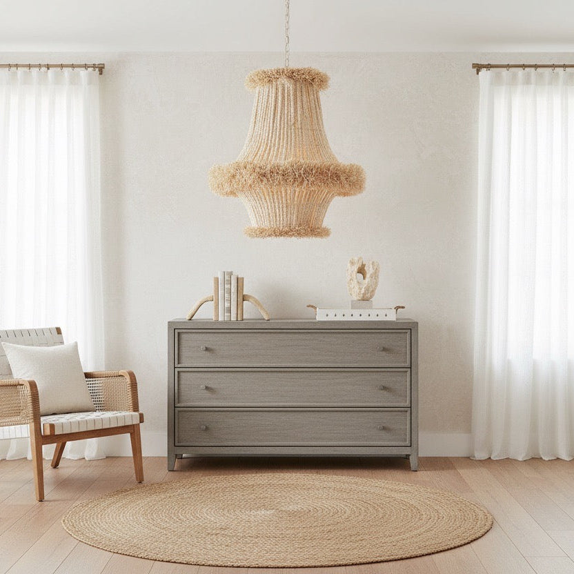 Modern interior with a gray dresser, chair, and decorative lamp.