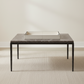 Modern coffee table with marble top and metal frame on a neutral background