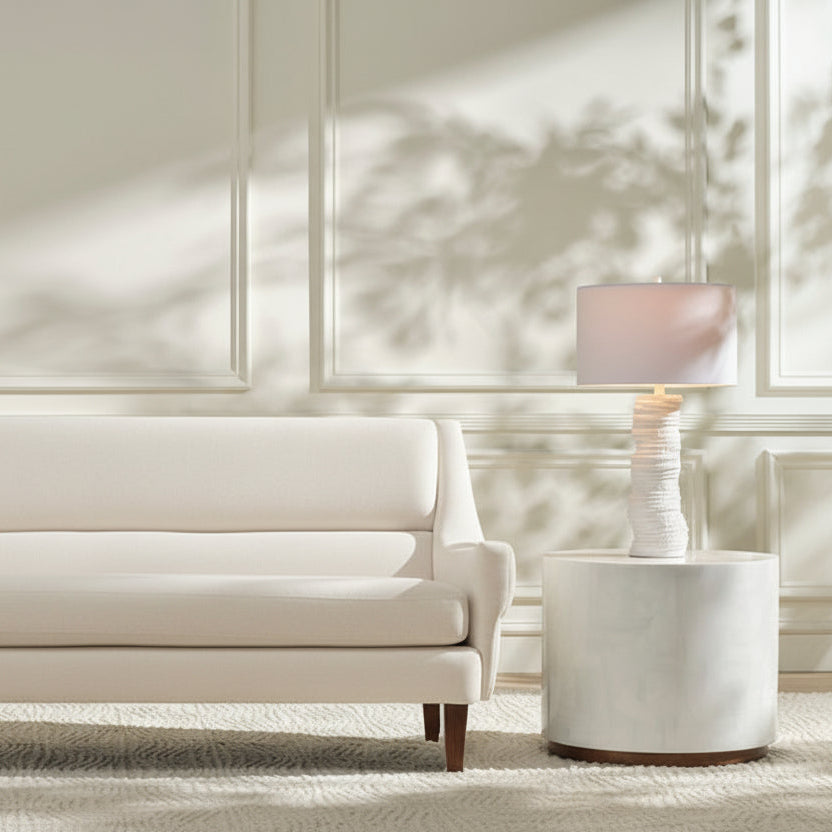 Blue sofa in a living room with a side table and lamp.