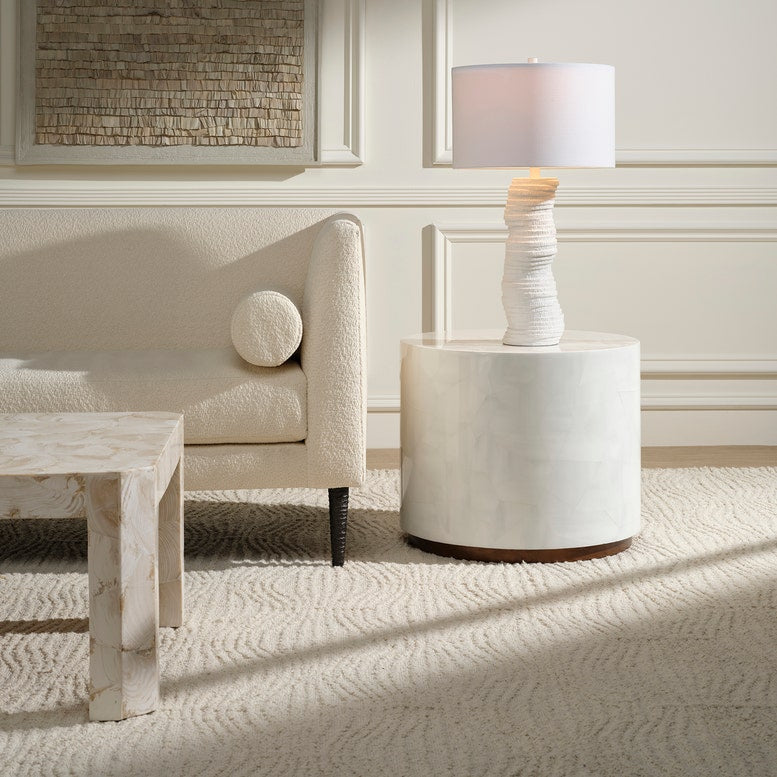 Modern living room with a white armchair, side table, and lamp.
