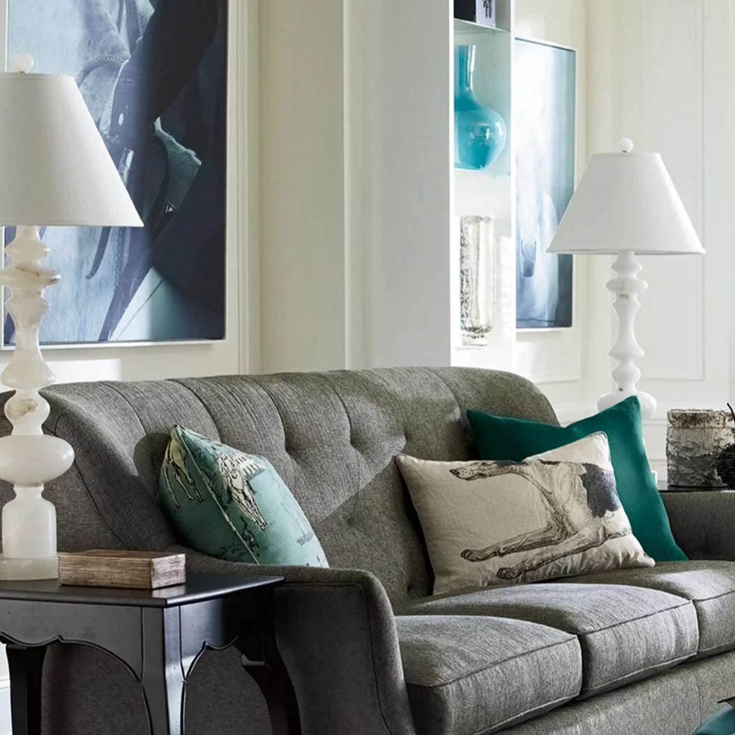 Living room with a gray sofa, decorative pillows, and a patterned rug.
