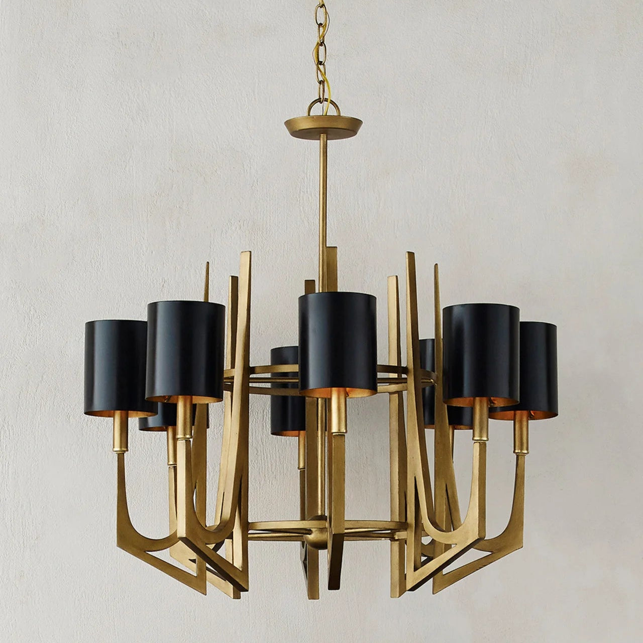 Gold chandelier with black lampshades on a neutral background
