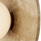 Close-up of a textured stone surface with a beige bowl.