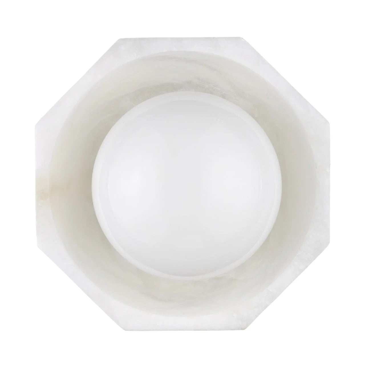 Hexagonal white marble bowl with a spherical white stone inside on a white background