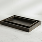 Dark wooden tray on a light marble surface