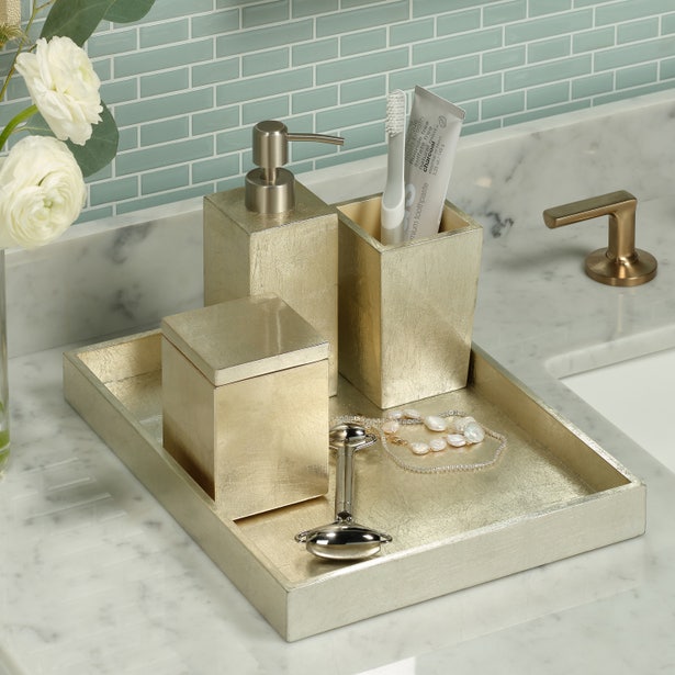 Bathroom accessories set on a tray with a sink and tiles in the background