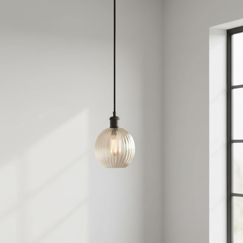 Pendant light fixture hanging in a room with a window on a gray wall