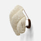 Decorative wall sconce with white beaded design and brown leather strap on a white background