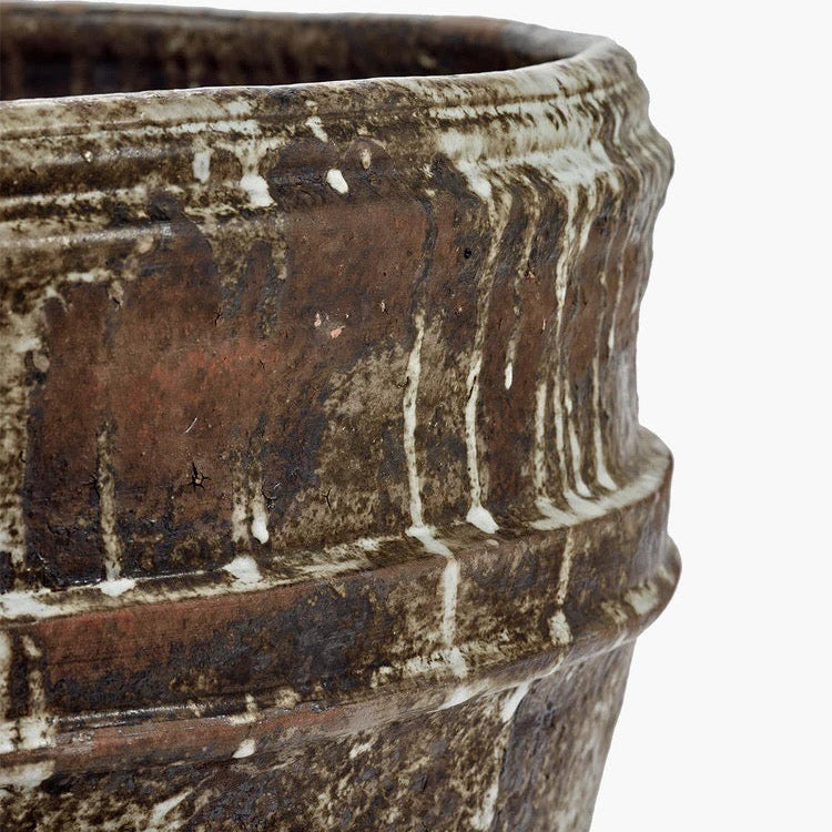 Close-up of a textured brown ceramic pot on a white background
