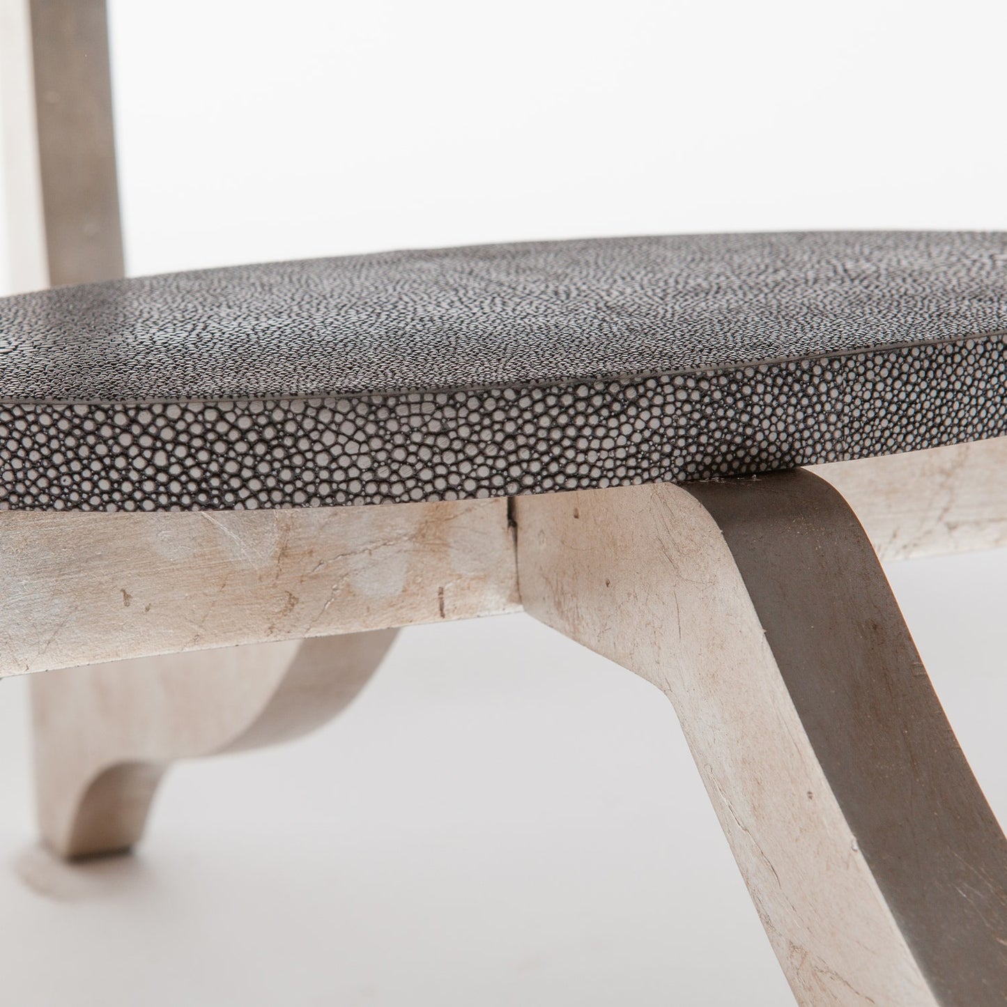 Close-up of a chair with a textured gray cushion on a white background