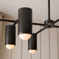 Modern black chandelier with three cylindrical lights on a neutral background