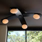 Modern ceiling light fixture with four round lights on a dark ceiling.