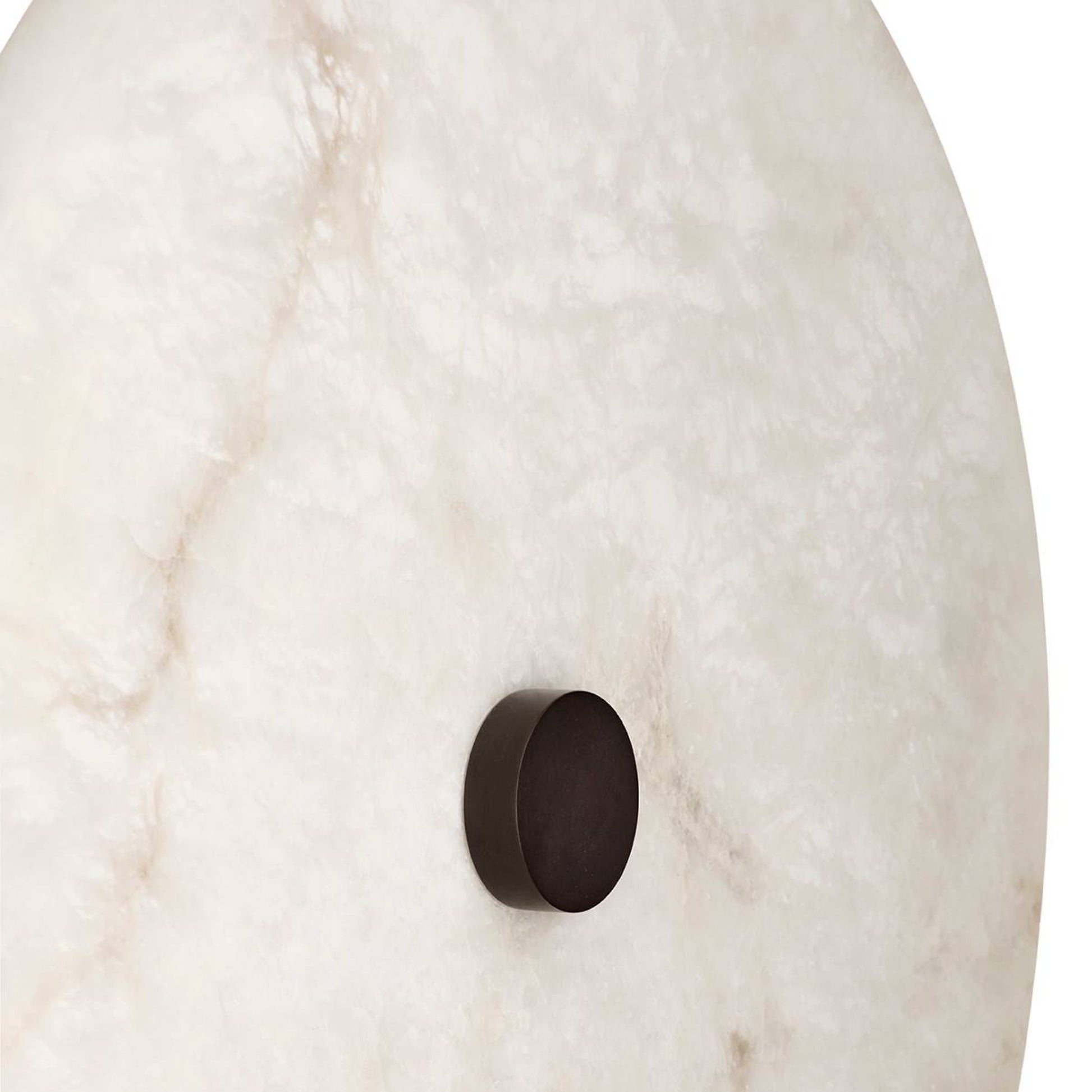 Round metallic object on a textured white surface