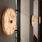Round wall lights on a neutral wall with a window in the background
