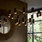 Modern chandelier hanging in a room with a mirror and window view