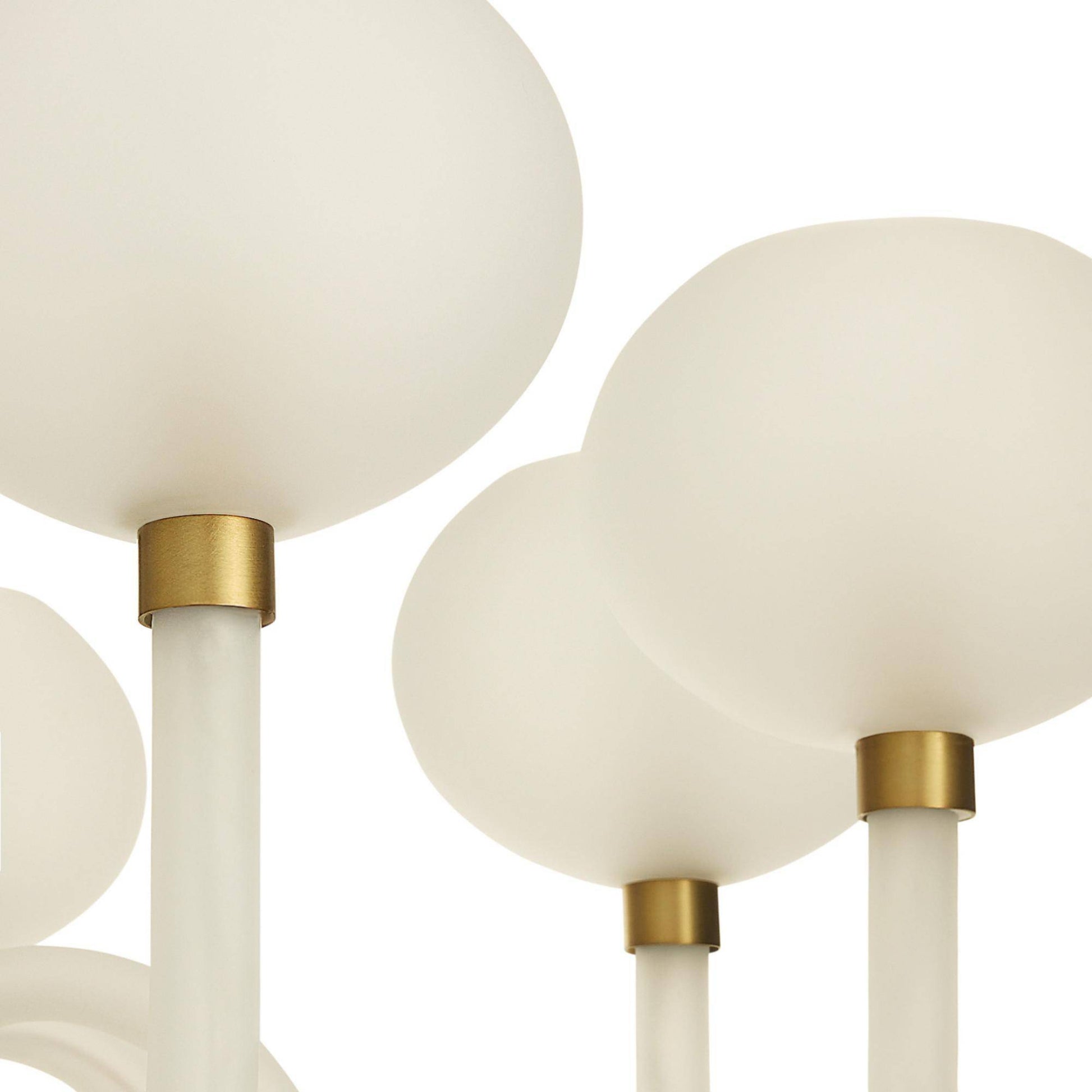 Close-up of a modern chandelier with spherical glass shades and brass fixtures on a white background.
