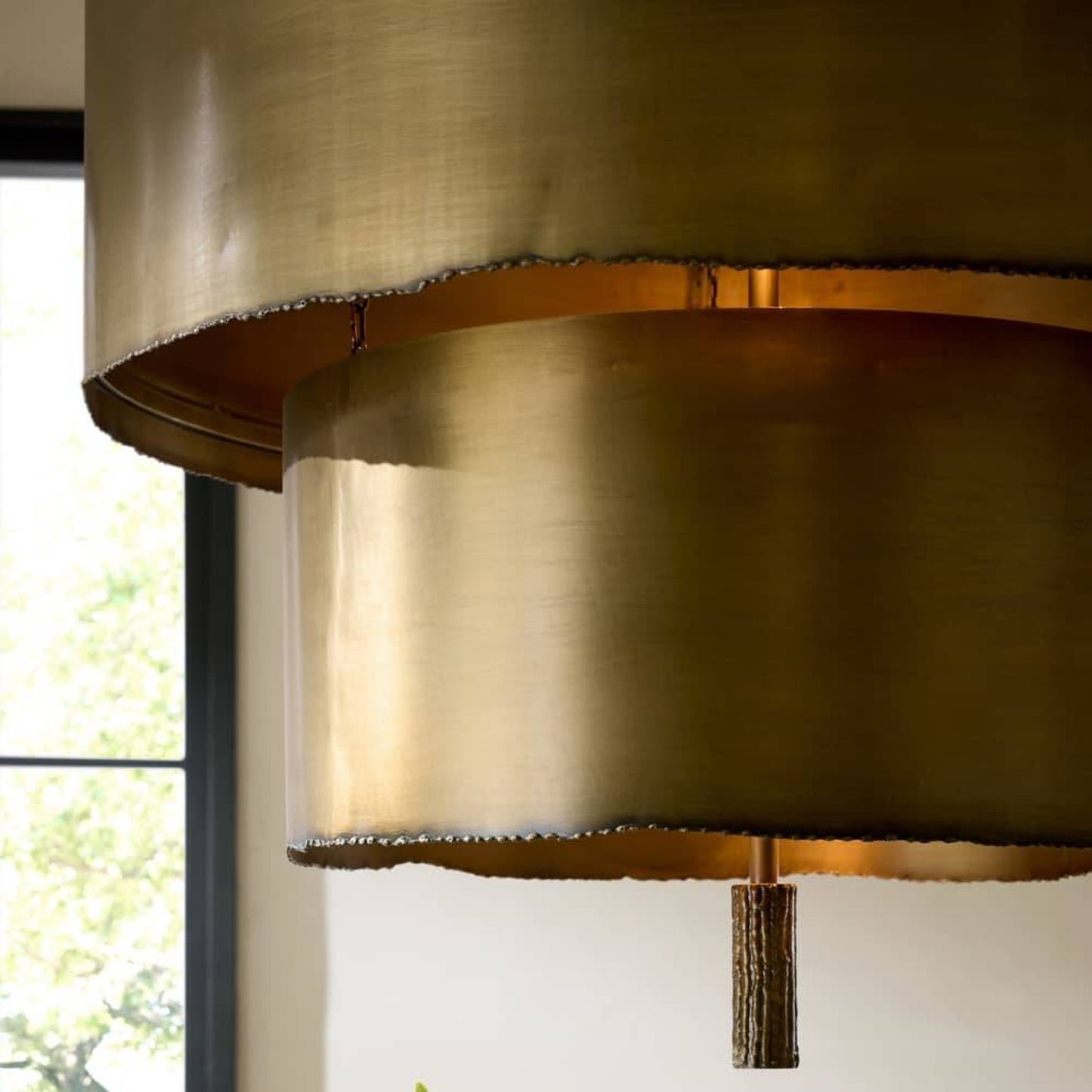 Close-up of a gold pendant light fixture with a blurred background