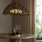 Decorative pendant light with intricate design on a table against a neutral wall.