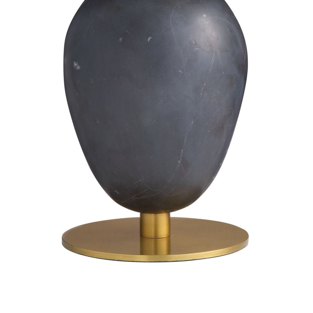 Dark gray marble object on a gold stand against a white background