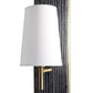 Wall-mounted light fixture with white shade and gold fixture against a textured wall.