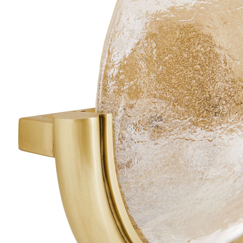 Close-up of a decorative item with gold handle and textured beige surface
