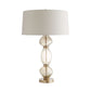 Table lamp with a beige shade and glass base on a white background