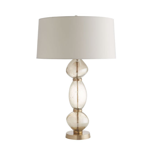 Table lamp with a beige shade and glass base on a white background