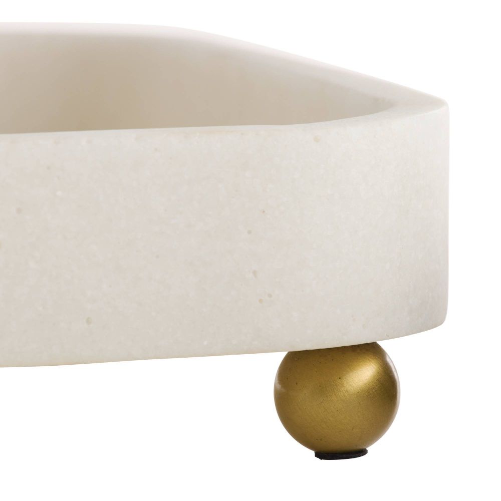 Close-up of a table with a beige cushion and gold leg on a white background