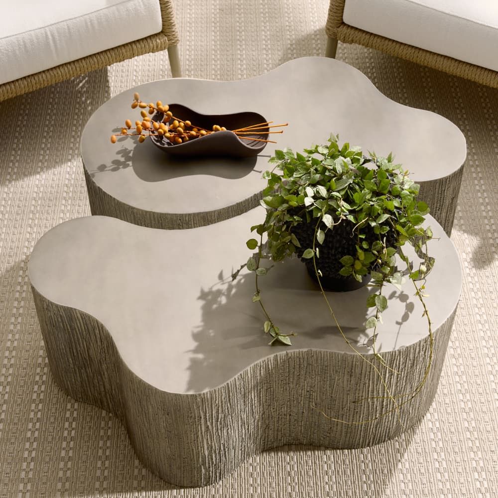 Wavy coffee table with decorative items on a textured floor