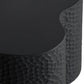 Close-up of a textured black stool with a round seat.