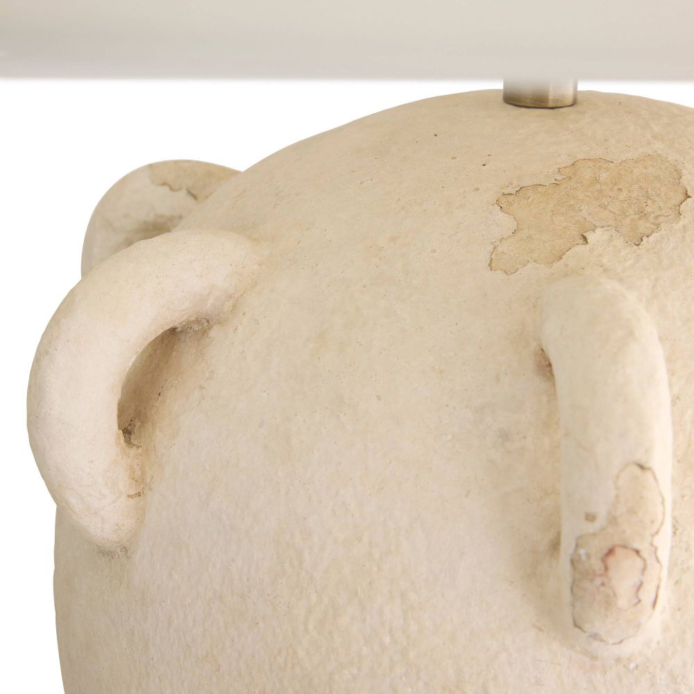 Close-up of a textured white ceramic vase with a light source above.