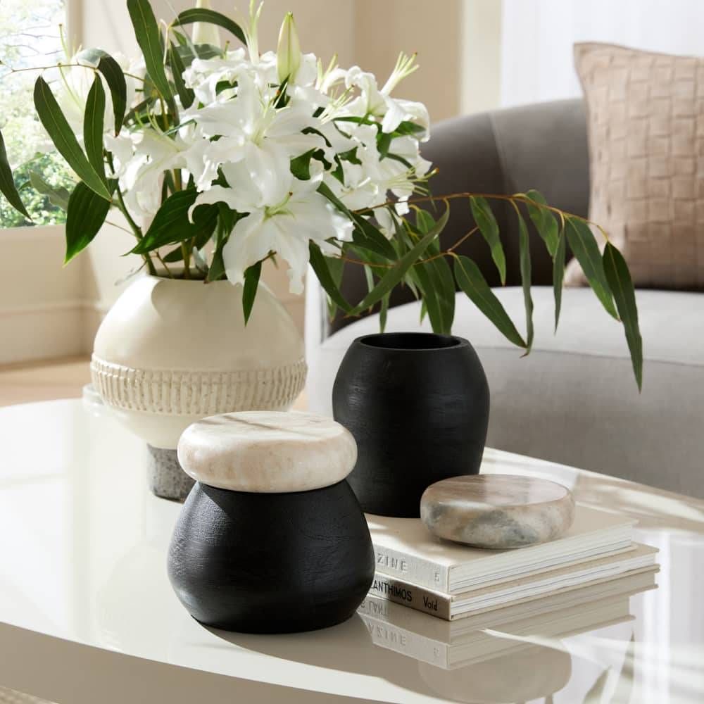 Decorative vases and a flower arrangement on a coffee table in a living room.