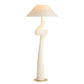 Decorative floor lamp with a white base and beige shade on a white background