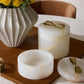 Set of marble containers with gold accents on a wooden surface.