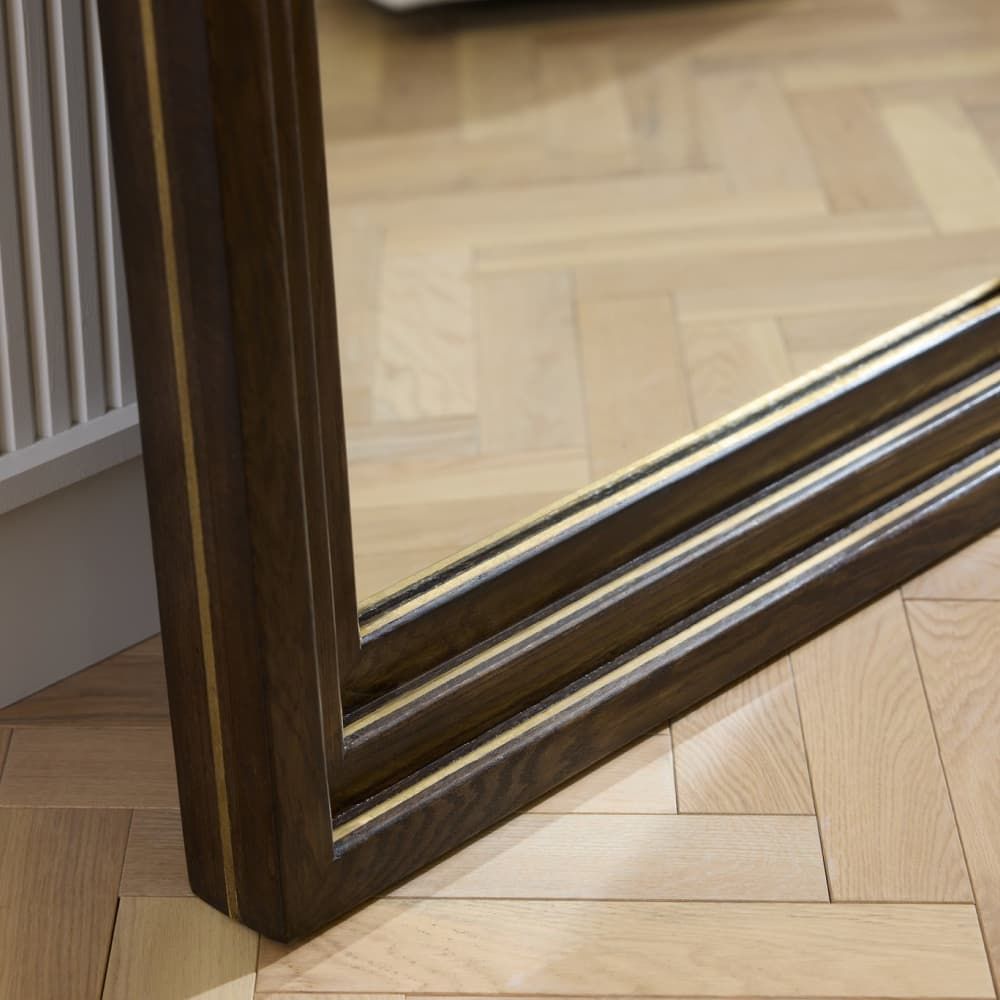 Wooden-framed mirror on a wooden floor