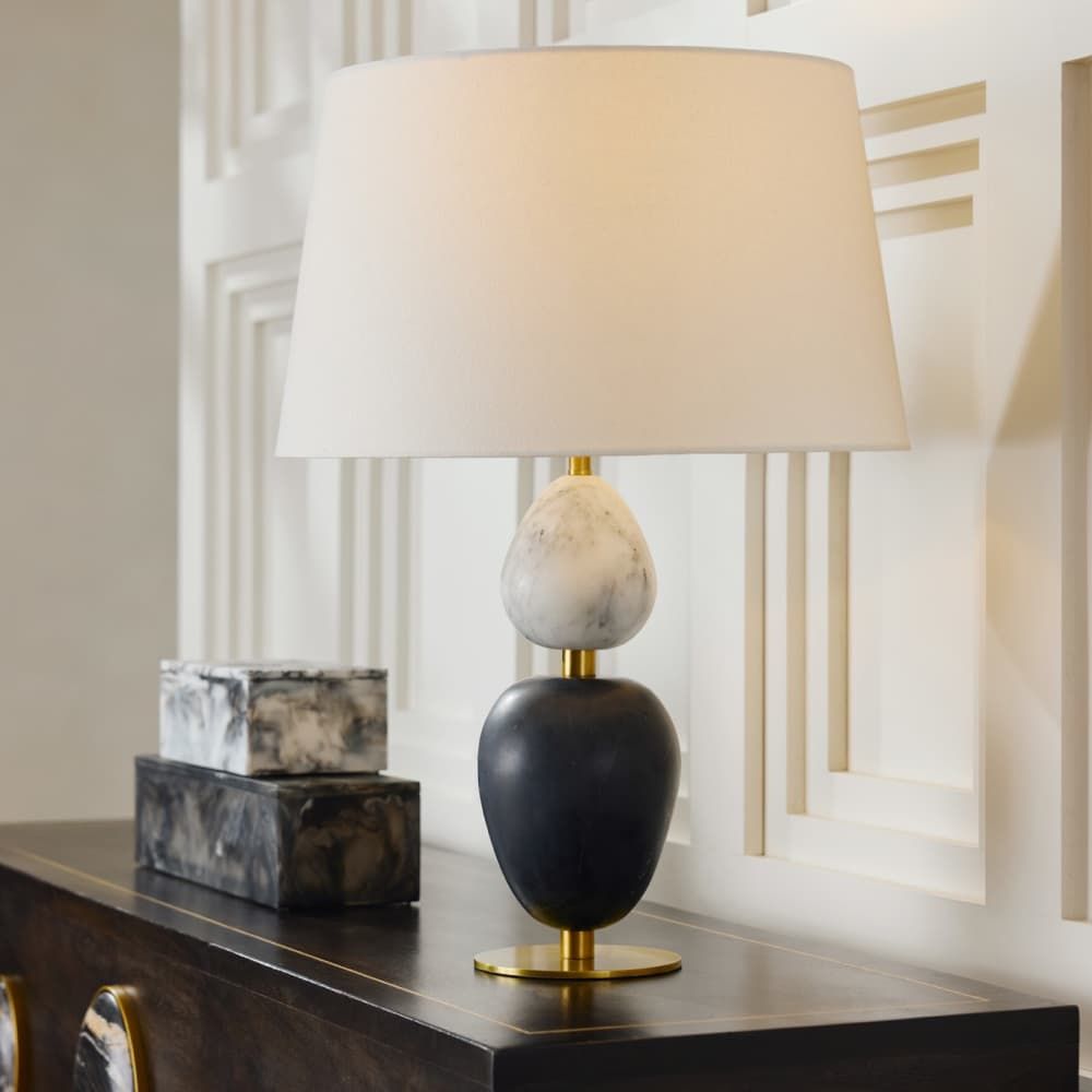 Decorative table lamp with marble accents on a wooden surface.