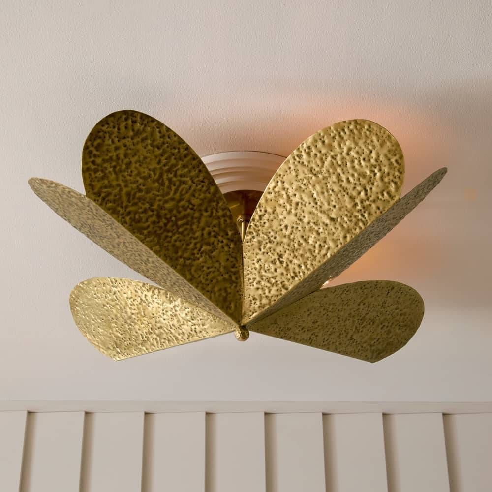 Gold ceiling light fixture with leaf-like design on a neutral background