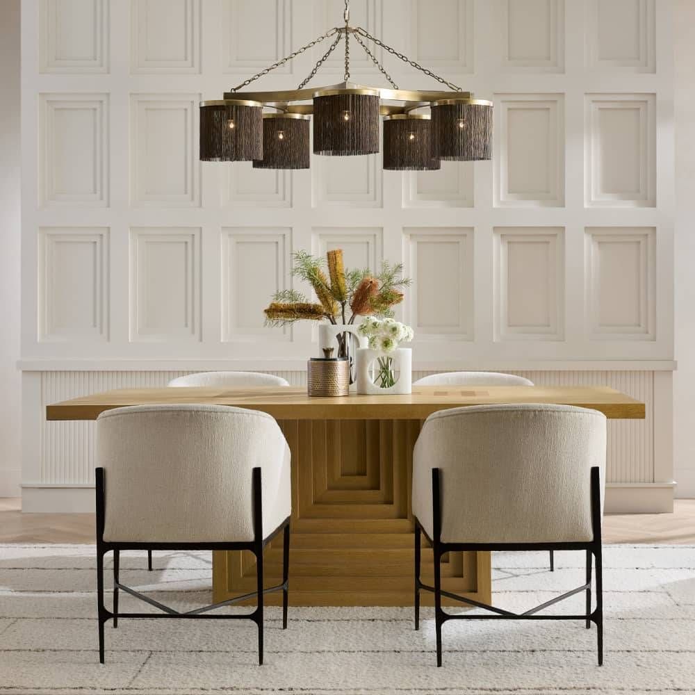 Dining room with wooden table, chairs, and decorative elements against a paneled wall.